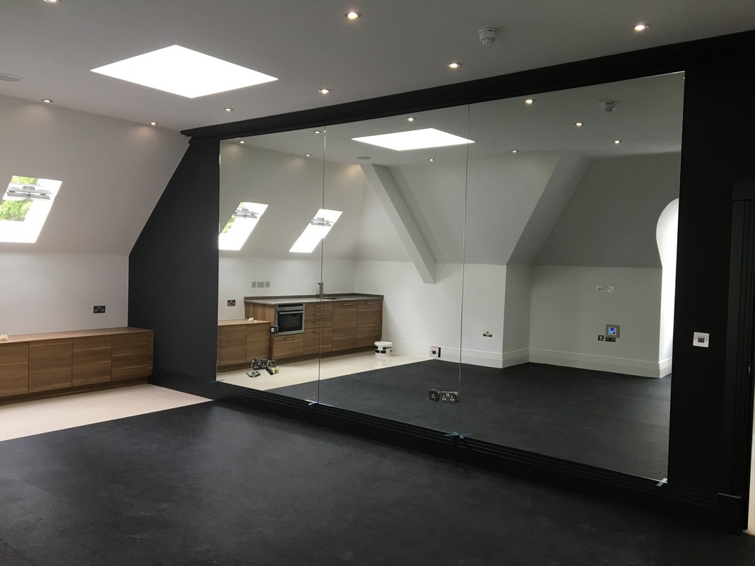 Frameless glass wall dividing loft conversion in West Brompton